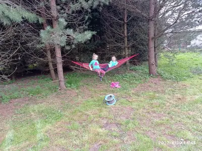 two children sitting in a hammock in a field at Gospodarstwo Agroturystyczne U Stasików in Spytkowice