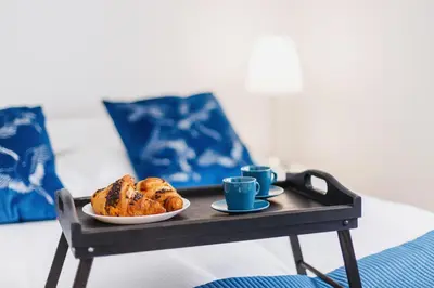 a tray with a plate of food and two cups of coffee at Apartment Smoluchowskiego Cracow by Noclegi Renters in Kraków