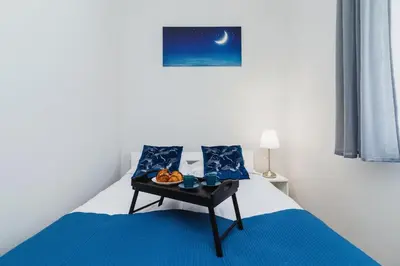 a bedroom with a bed with a table with food on it at Apartment Smoluchowskiego Cracow by Noclegi Renters in Kraków