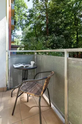 a chair and a table on a balcony at Apartment Smoluchowskiego Cracow by Noclegi Renters in Kraków