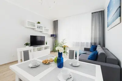 a living room with a couch and a table at Apartment Smoluchowskiego Cracow by Noclegi Renters in Kraków