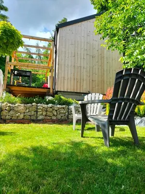 two black and white chairs sitting in the grass at Mały domek w Dolinie Prądnika in Sułoszowa