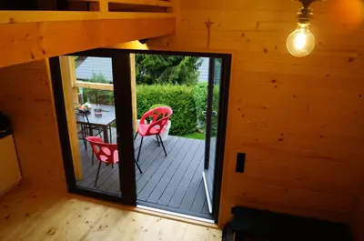 an open door to a deck with a table and chairs at Mały domek w Dolinie Prądnika in Sułoszowa