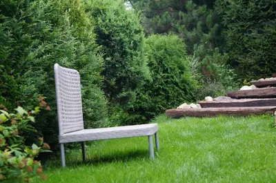 a white chair sitting in the grass in a yard at Mały domek w Dolinie Prądnika in Sułoszowa