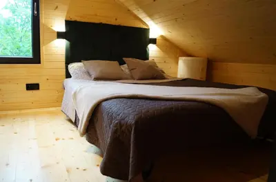 a bedroom with a large bed in a wooden cabin at Mały domek w Dolinie Prądnika in Sułoszowa