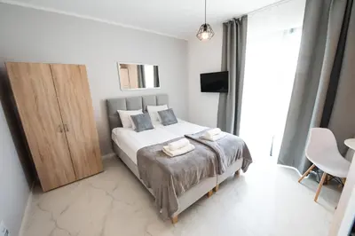 a bedroom with a bed with two towels on it at Estella Apartment in Kraków