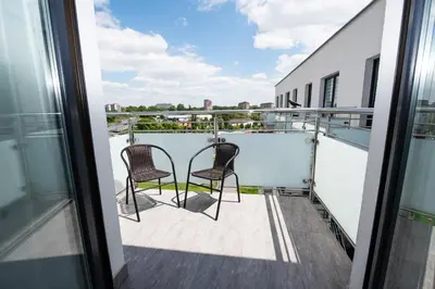 a balcony with two chairs on top of a building at Estella Apartment in Kraków