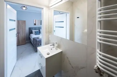 a bathroom with a sink and a mirror at Estella Apartment in Kraków