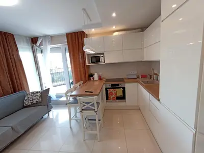 a kitchen and living room with a couch and a table at APARTAMENTY BARSKA 69 in Kraków
