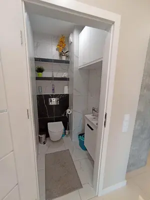 a white bathroom with a toilet and a sink at APARTAMENTY BARSKA 69 in Kraków