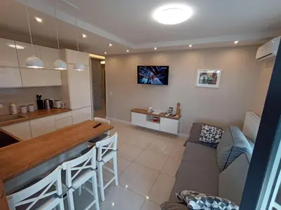 a kitchen and living room with a table and a couch at APARTAMENTY BARSKA 69 in Kraków