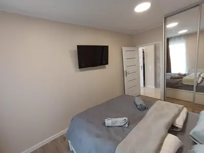 a bedroom with a bed and a tv on the wall at APARTAMENTY BARSKA 69 in Kraków
