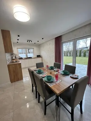 a dining room with a wooden table and chairs at ZATOR Apartamenty Max House, Energylandia in Zator