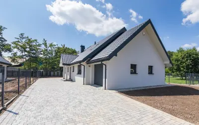 a white house with a black roof and a driveway at ZATOR Apartamenty Max House, Energylandia in Zator