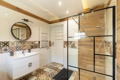 a bathroom with a shower and a sink and a mirror at ZATOR Apartamenty Max House, Energylandia in Zator
