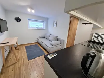 a kitchen and living room with a couch and a table at Apartament Łąki18 in Wadowice