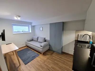 a small living room with a couch and a window at Apartament Łąki18 in Wadowice