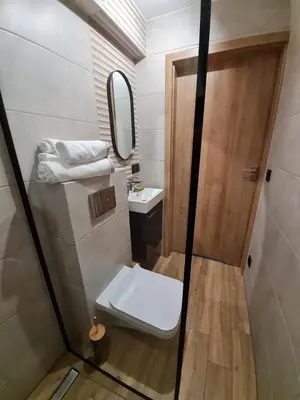 a small bathroom with a sink and a mirror at Apartament Łąki18 in Wadowice