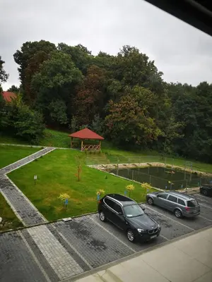 two cars parked in a parking lot next to a park at Apartament Źródełko in Bochnia