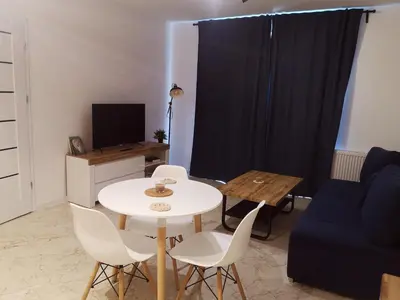 a living room with a white table and a blue couch at Apartament Źródełko in Bochnia