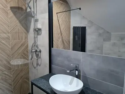 a bathroom with a sink and a shower at Hotel Savana in Kłaj