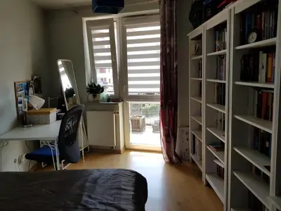 a bedroom with a desk and book shelves with books at Miło powitać Cię w Krakowie. in Kraków
