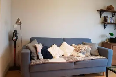 a blue couch with pillows on it in a living room at Miło powitać Cię w Krakowie. in Kraków
