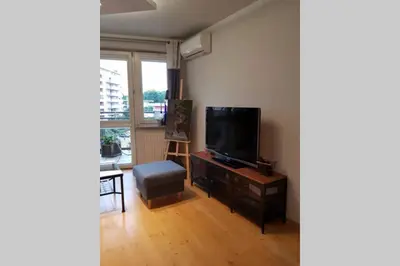 a living room with a television and a chair at Miło powitać Cię w Krakowie. in Kraków