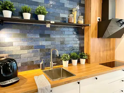 a kitchen with a sink and potted plants on a counter at RiversideSuite. Krakow in Kraków