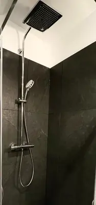 a shower with a shower head in a bathroom at RiversideSuite. Krakow in Kraków