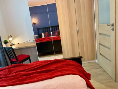a bedroom with a bed with a red blanket at RiversideSuite. Krakow in Kraków