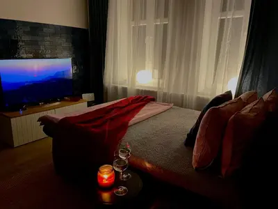 a bedroom with a bed with a television and a table with candles at RiversideSuite. Krakow in Kraków