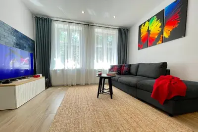 a living room with a couch and a flat screen tv at RiversideSuite. Krakow in Kraków
