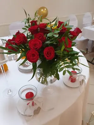 a vase filled with red roses on a table at NOCLEGI General in Wieliczka