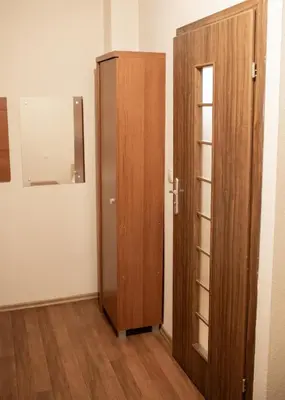 a wooden cabinet next to a door in a room at NOCLEGI General in Wieliczka