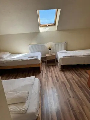 a room with three beds and a window at NOCLEGI General in Wieliczka