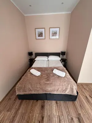 a bedroom with a bed with two towels on it at NOCLEGI General in Wieliczka