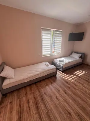 two beds in a room with wooden floors at NOCLEGI General in Wieliczka