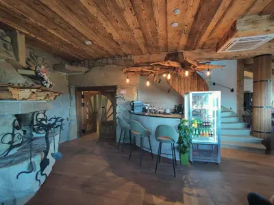 a kitchen with a bar in a room with wooden ceilings at Wrzosowy Dwór - SPA in Skomielna Czarna