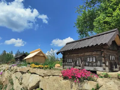 a log cabin in a garden with flowers at Wrzosowy Dwór - SPA in Skomielna Czarna