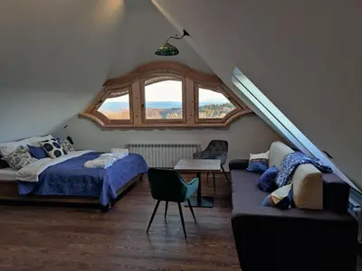 a bedroom with a bed and a couch and a window at Wrzosowy Dwór - SPA in Skomielna Czarna