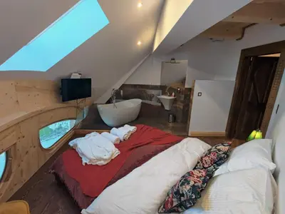 a bedroom with a bed and a bathroom with a sink at Wrzosowy Dwór - SPA in Skomielna Czarna