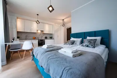 a bedroom with a large bed with towels on it at Drwinka Park Apartment in Kraków