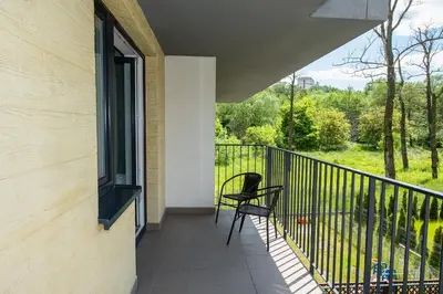 a balcony with a chair and a window at Drwinka Park Apartment in Kraków