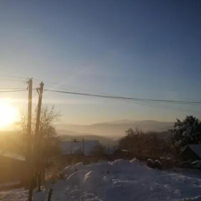 a snowy hill with the sun in the background at Michalka 1 - Domki pod Leskowcem in Targoszów