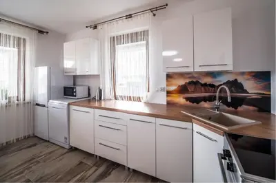 a white kitchen with white cabinets and a sink at Michalka 1 - Domki pod Leskowcem in Targoszów
