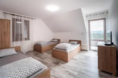 a bedroom with two beds and a large window at Michalka 2 - Domki pod Leskowcem in Targoszów