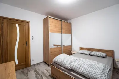 a bedroom with a bed and a wooden cabinet at Michalka 2 - Domki pod Leskowcem in Targoszów