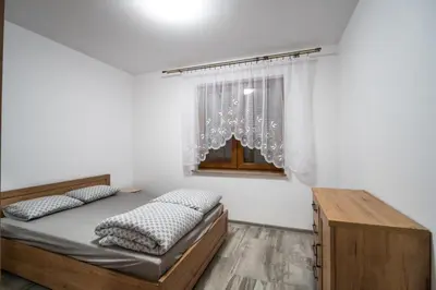 a bedroom with a bed and a window at Michalka 2 - Domki pod Leskowcem in Targoszów