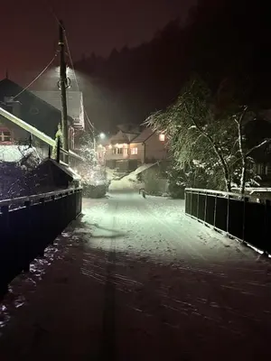 a snow covered street at night with lights at Ojców, Na Widoku in Ojców